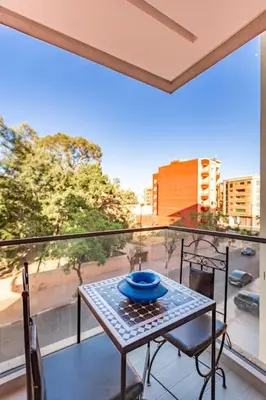 a balcony with a table and a view of a city at New ! Bright And Comfortable App in city center in Marrakech