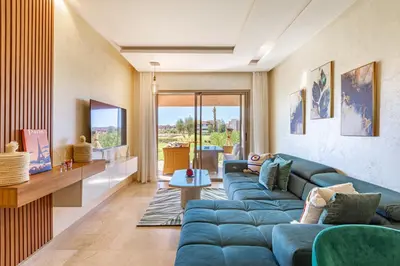 a living room with a blue couch and a table at Résidence Golfique ,Piscine,Jardin terrasse privée in Marrakech
