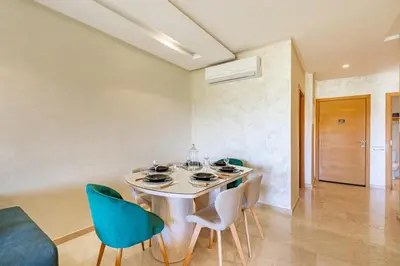 a dining room with a table and chairs at Résidence Golfique ,Piscine,Jardin terrasse privée in Marrakech