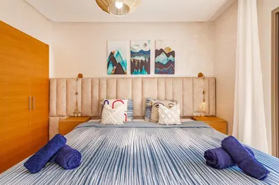a bedroom with a bed with purple pillows on it at Résidence Golfique ,Piscine,Jardin terrasse privée in Marrakech