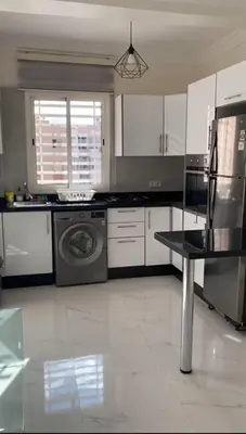 a kitchen with white cabinets and a washer at appartement de luxe a Marrakech in Marrakech