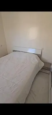 a bed in a room with a white pillow at appartement de luxe a Marrakech in Marrakech