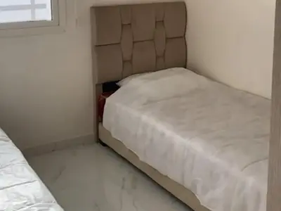 a small bedroom with two beds and a window at appartement de luxe a Marrakech in Marrakech