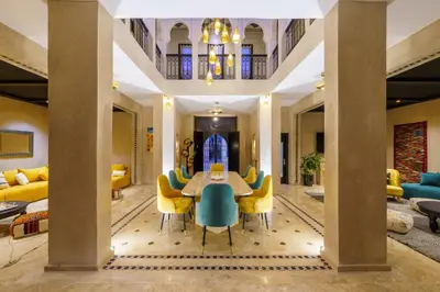 a dining room with a table and yellow chairs at Villa Riad Sultana in Marrakech
