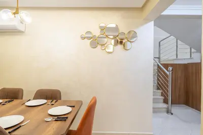 a dining room with a table and chairs and a staircase at Cozy appartement à Gueliz juste les familles in Marrakech