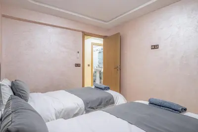 a room with three beds and a window at Cozy appartement à Gueliz juste les familles in Marrakech