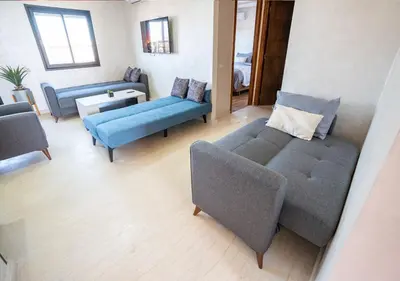 a living room with two couches and a blue couch at Appart Mayar 58 in Marrakech