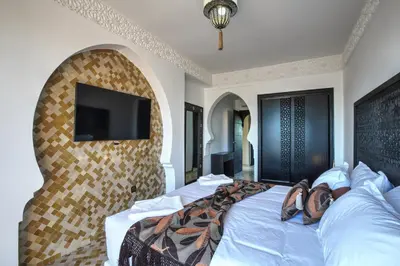 a bedroom with a bed with a tv on a wall at Villa Akadia luxurious with private swimming pool in Marrakech