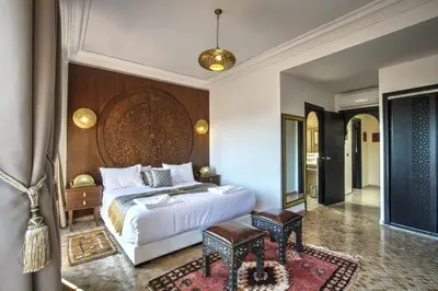 a bedroom with a large bed with a wooden headboard at Villa Akadia luxurious with private swimming pool in Marrakech