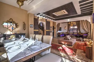 a dining room with a table and chairs and a living room at Villa Akadia luxurious with private swimming pool in Marrakech