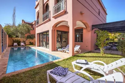 a backyard with a swimming pool and a house at Villa Akadia luxurious with private swimming pool in Marrakech