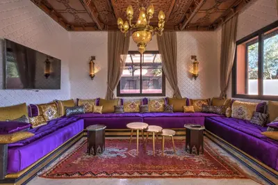 a living room with purple couches and a chandelier at Villa Akadia luxurious with private swimming pool in Marrakech