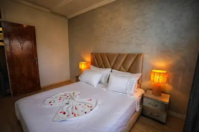 a bedroom with a large white bed with two lamps at La Nina Appartement Marrakech in Marrakech