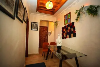 a dining room with a glass table and orange chairs at La Nina Appartement Marrakech in Marrakech