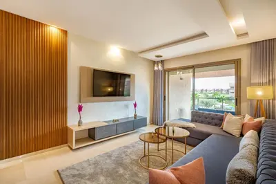 a living room with a couch and a tv at New! Résidence de Luxe avec Piscine & parking in Marrakech