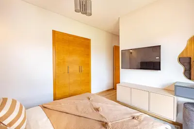 a bedroom with a bed and a tv on a wall at New! Résidence de Luxe avec Piscine & parking in Marrakech