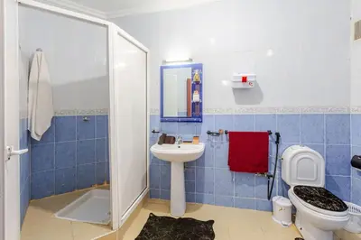 a blue tiled bathroom with a toilet and a sink at Séjour Authentique à Marrakech Confort et Charme in Marrakech