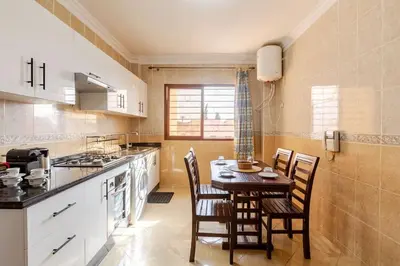 a kitchen with a table and chairs in a kitchen at Séjour Authentique à Marrakech Confort et Charme in Marrakech