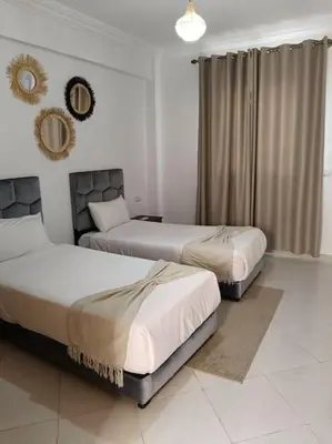 a bedroom with two beds and a mirror on the wall at Family House Marrakech in Marrakech