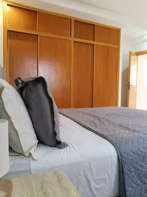 a bedroom with a bed with a wooden headboard at Family House Marrakech in Marrakech