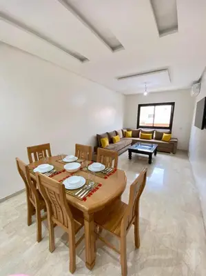 a dining room and living room with a table and chairs at Condo in Marrakech in Marrakech