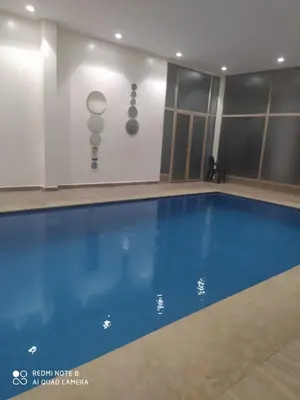 a swimming pool in a building with a blue pool at Condo in Marrakech in Marrakech