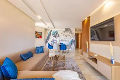 a living room with a couch and a tv at New! App Spacieux avec Piscine et Parking à Saphir in Marrakech