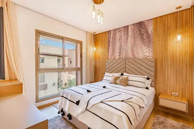 a bedroom with a large bed and a window at New! App Spacieux avec Piscine et Parking à Saphir in Marrakech