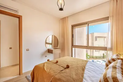 a bedroom with a bed and a window at New! App Spacieux avec Piscine et Parking à Saphir in Marrakech