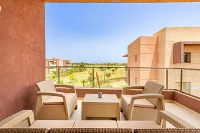 a balcony with chairs and a table with a view at New! App Spacieux avec Piscine et Parking à Saphir in Marrakech