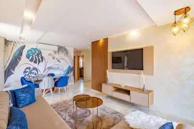 a living room with a couch and a tv at New! App Spacieux avec Piscine et Parking à Saphir in Marrakech