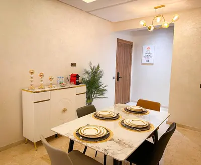 a dining room with a table and chairs at Bel appartement haut standing in Marrakech