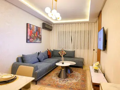 a living room with a couch and a table at Bel appartement haut standing in Marrakech
