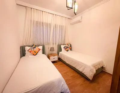a bedroom with two beds and a window at Bel appartement haut standing in Marrakech