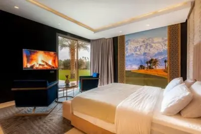 a bedroom with a large bed and a television at Villa des stars in Marrakech