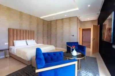 a hotel room with a bed and a blue chair at Villa des stars in Marrakech