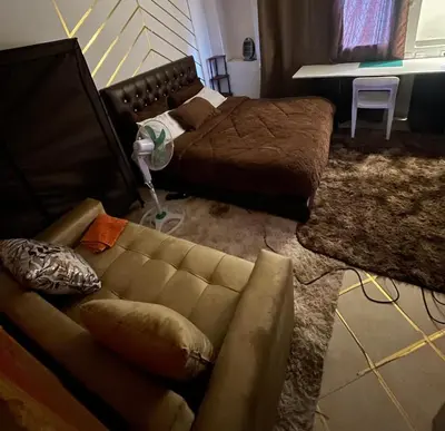 a living room with a couch and a bed at Your Home Away From Home in Marrakech