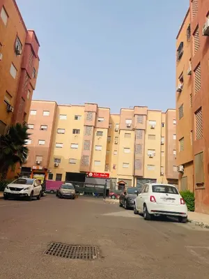 a parking lot with cars parked in front of a building at Your Home Away From Home in Marrakech