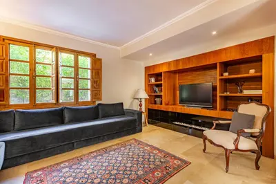 a living room with a black couch and a tv at Villa Dar Chama ,piscine privée , Au cœur de Marrakech in Marrakech