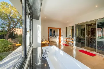 a bath tub in a room with a large window at Villa Dar Chama ,piscine privée , Au cœur de Marrakech in Marrakech