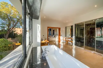 a bath tub in a room with a large window at Villa Dar Chama ,piscine privée , Au cœur de Marrakech in Marrakech