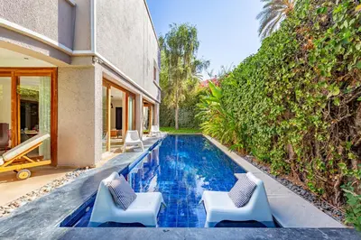 a swimming pool with two chairs and a house at Villa Dar Chama ,piscine privée , Au cœur de Marrakech in Marrakech