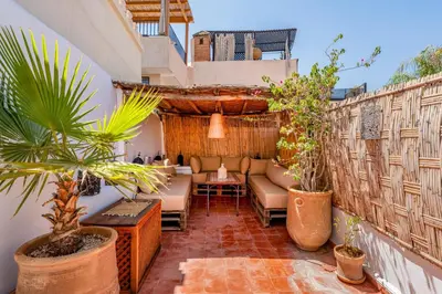 a patio with a couch and plants on a balcony at Dar Karole-Privé-petits déjeuners inclus in Marrakech
