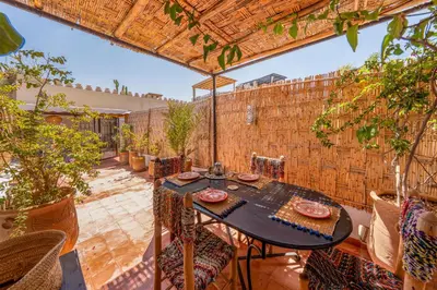 an outdoor patio with a table and chairs at Dar Karole-Privé-petits déjeuners inclus in Marrakech