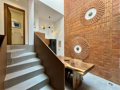 a staircase with a wooden table next to a brick wall at Riad Ziya - Private very close to Jamaa El Fna in Marrakech