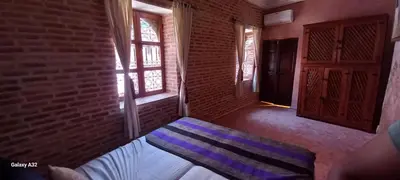 a room with a bed and a brick wall at Riad maison Bounouar in Marrakech