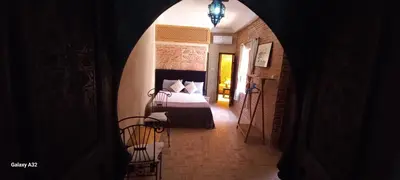 a bedroom with a bed in a room with a hallway at Riad maison Bounouar in Marrakech