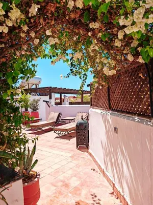 an archway with chairs and flowers on a patio at Riad maison Bounouar in Marrakech