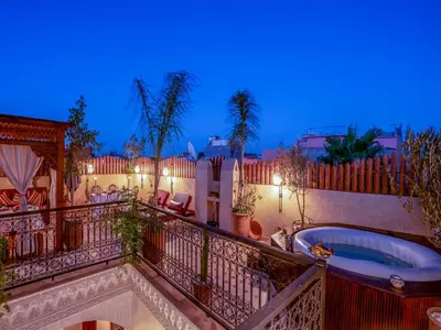 a balcony with a hot tub on it at night at Riad Le Nid De Fatima in Marrakech