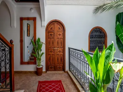 a hallway with a wooden door and plants at Riad Le Nid De Fatima in Marrakech